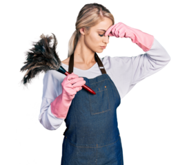 Beautiful young blonde woman wearing apron holding cleaning duster tired rubbing nose and eyes feeling fatigue and headache. stress and frustration concept.