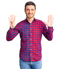 Handsome young man with bear wearing casual shirt showing and pointing up with fingers number nine while smiling confident and happy.