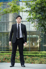 Asian business man standing outside.