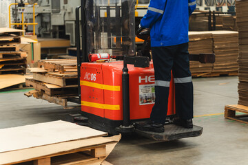An expert professional Female worker driving forklift in industrial, storehouse or warehouse container. Concept of transportation, installing or loading stock, vehicle service of manufacturing factory