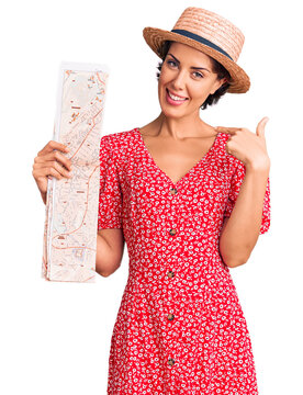 Young beautiful woman wearing summer hat holding map pointing finger to one self smiling happy and proud