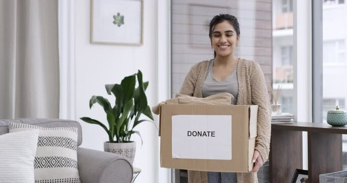 Woman, face and donation in home, charity box and kindness with happy giving to ngo organisation. Volunteer, pride or smile portrait by clothing box, cardboard or service to community with generosity