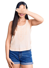 Young beautiful caucasian woman wearing casual clothes and glasses smiling and laughing with hand on face covering eyes for surprise. blind concept.