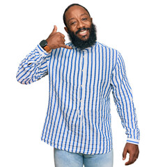 Young african american man wearing business shirt smiling doing phone gesture with hand and fingers like talking on the telephone. communicating concepts.