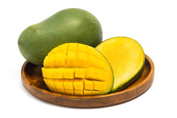 Sliced half cut into cubes and whole fresh organic green mango delicious fruit front view in a wooden plate isolated on white background clipping path
