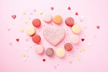 Fotobehang macarons arranged in a heart shape on pink background © studioworkstock
