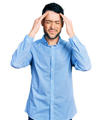 Hispanic man with beard wearing casual business shirt with hand on head for pain in head because...