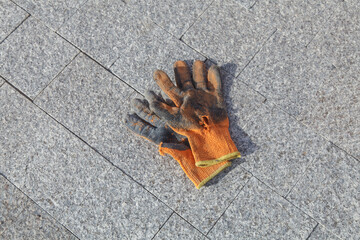 Work glove.Old cloth gloves lie on a stone block for a worker