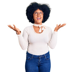 Young african american girl wearing casual clothes and glasses crazy and mad shouting and yelling...