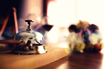 Vintage bell stands on wooden counter to attract attention