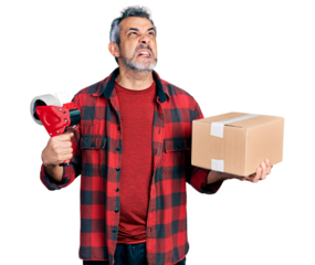 Middle age hispanic with grey hair holding packing tape and cardboard box angry and mad screaming frustrated and furious, shouting with anger looking up.