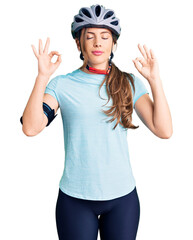 Beautiful caucasian young woman wearing bike helmet relax and smiling with eyes closed doing meditation gesture with fingers. yoga concept.