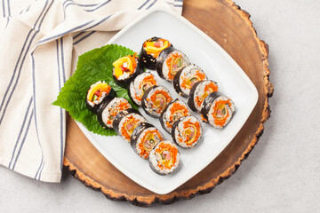 A food where rice is spread on seaweed, stuffed with various side dishes, wrapped, wrapped, and eaten sliced.


