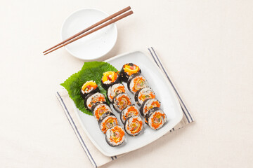 A food where rice is spread on seaweed, stuffed with various side dishes, wrapped, wrapped, and eaten sliced.


