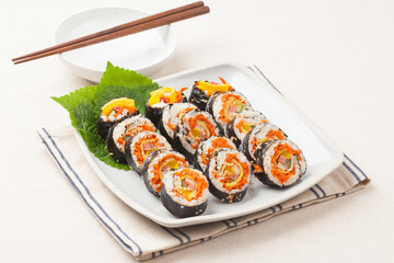 A food where rice is spread on seaweed, stuffed with various side dishes, wrapped, wrapped, and eaten sliced.


