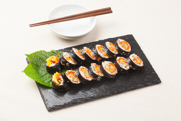 A food where rice is spread on seaweed, stuffed with various side dishes, wrapped, wrapped, and eaten sliced.


