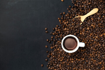 Coffee beans and cup on black background. Copyspace for your text