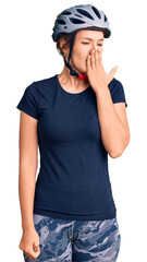 Beautiful caucasian woman wearing bike helmet bored yawning tired covering mouth with hand. restless and sleepiness.
