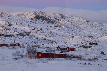 beautiful winter landscape with red houses and mountains in Norway