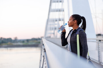 Woman drinking water after morning workout session