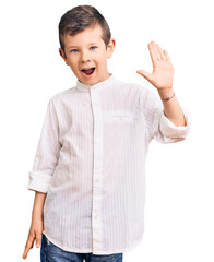 Cute blond kid wearing elegant shirt waiving saying hello happy and smiling, friendly welcome...