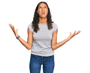 Young african american girl wearing casual clothes crazy and mad shouting and yelling with aggressive expression and arms raised. frustration concept.