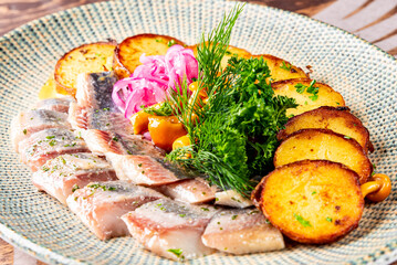fish herring fillet with potatoes, mushrooms and onions on plate