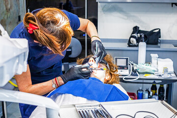 dentist injecting anesthesia into a diseased tooth before treating it