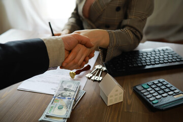 European businesswoman working in real estate company. She is giving cash money to male customer.