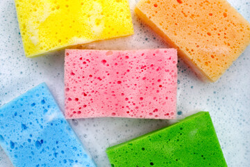 Cleaning sponge in foam of dishwashing liquid. Washing dishes concept