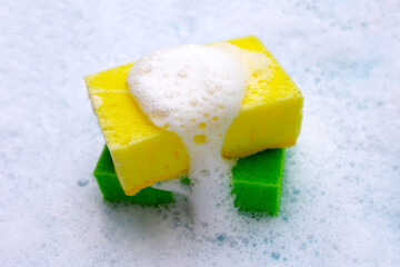 Cleaning sponge in foam of dishwashing liquid. Washing dishes concept