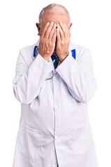 Senior handsome grey-haired man wearing doctor coat and stethoscope with sad expression covering face with hands while crying. depression concept.