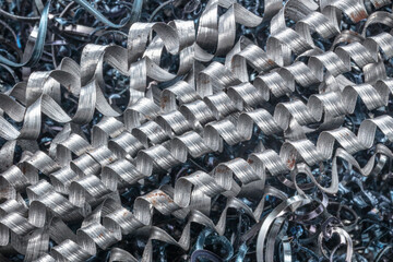 Metal spiral shavings after working on a lathe. Angled view. Background for design.