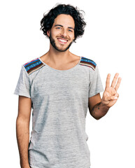 Young hispanic man wearing casual t shirt showing and pointing up with fingers number three while smiling confident and happy.