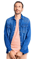 Young handsome man wearing casual clothes smiling looking to the side and staring away thinking.