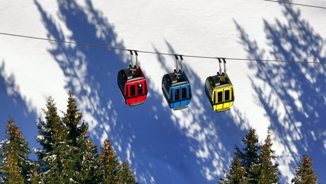 Cable cars moving to the top of a mountain in wintertime. Drone folow shot