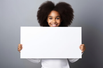 Happy black scholl girl holding blank white banner sign, isolated studio portrait.