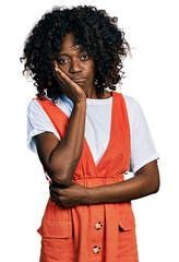 Fototapeta na wymiar African woman with curly hair wearing casual white t shirt thinking looking tired and bored with depression problems with crossed arms.