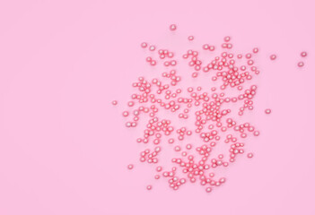 Decorative small pink balls on a pink background. Holidays concept. Copy space. Top view.