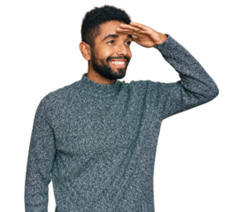 Young african american man wearing casual clothes very happy and smiling looking far away with hand over head. searching concept.