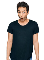 Obraz premium Young handsome man wearing casual black t shirt afraid and shocked with surprise expression, fear and excited face.
