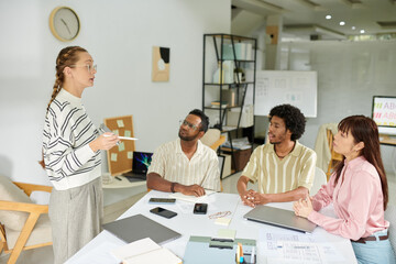 Marketing manager speaking in front of team in daily meeting
