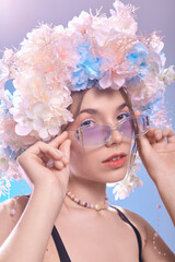 a woman in sunglasses and a flower wreath on a blue background