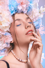 A beautiful woman with perfect makeup gently touches her lips with her fingers, closing her eyes
