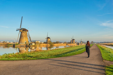 Dutch Windmill landscape at Kinderdijk Village Netherlands with woman tourist