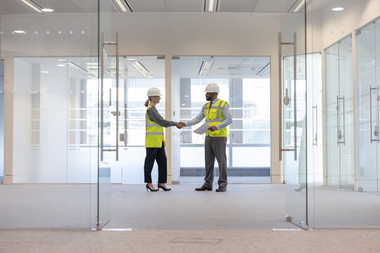 Businessman shaking hands with relator in new office space