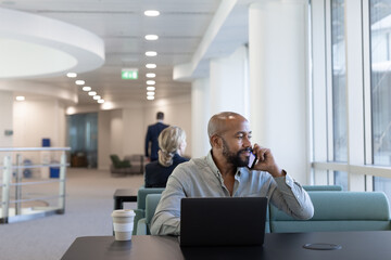 Businessman using smartphone in airport terminal lounge