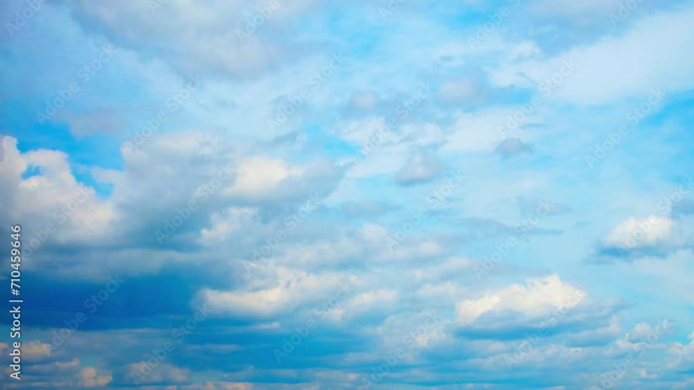 Wall mural white, cumulus clouds move and transform. above them, in a separate layer, the clouds move in the ot