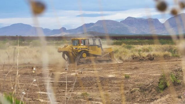 Yellow tracked bulldozer machine on a deserted dirty landscape. Crawler bulldozer machine moving sand. Earth moving machine.