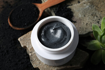 Natural cosmetics with charcoal on a dark background.